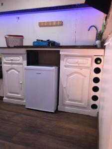a white kitchen with a sink and a dishwasher at Fandvan in Amadora