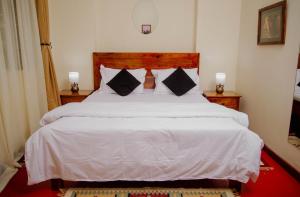 a bedroom with a large bed with white sheets and pillows at Protea House in Marombosa