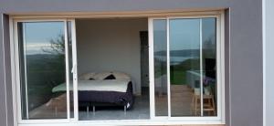 HanvecにあるChambre avec terrasse privative et vue merのガラスの引き戸が付いたバルコニーにベッドが置かれた部屋