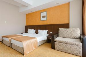 a hotel room with a bed and a chair at Hotel Clermont in Covasna +69 photos
