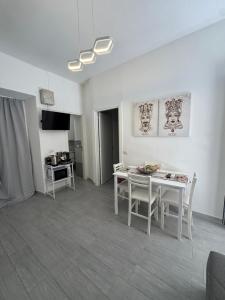 a living room with a white table and chairs at Marea Apartment's in Letojanni