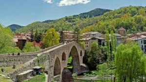 a bridge over a river in a town with buildings at Casa Filomena apartamento de diseño en St. Joan de les Abadesses in Sant Joan de les Abadesses