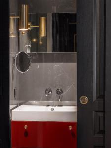 a bathroom with a red sink and a mirror at Snob Hotel in Paris