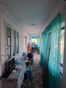 a living room with blue curtains and a couch at Casa Antonyo in Jurilovca