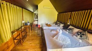 two beds in a room with yellow walls at The Rock & Paddy Resort in Sigiriya