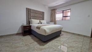 a bedroom with a large bed and a window at 7th Heaven Boutique Hotels in Burgersfort