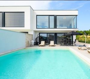 a villa with a swimming pool and a house at Melanie in Mazurija