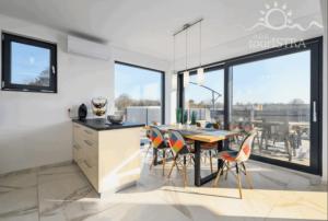 a kitchen and dining room with a table and chairs at Melanie in Mazurija +8 photos