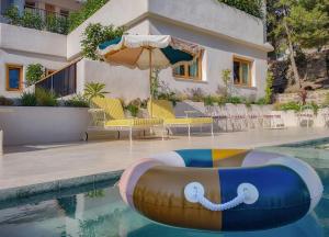 a swimming pool with an inflatable raft in front of a house at Nomad Boutique Resort Benidorm in Benidorm