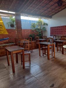 una sala da pranzo con tavoli e sedie in legno di Pousada Santa Luzia a Luis Correia