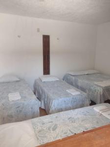una stanza con tre letti in una stanza di Pousada Santa Luzia a Luis Correia