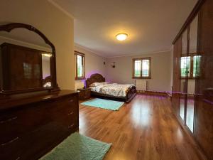 a bedroom with a bed and a dresser with a mirror at Будинок відпочинку подобово in Ivano-Frankivsʼk