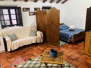 a living room with a couch and a bed at Moinho do Avô in Pataias