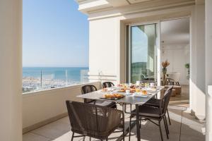 a dining room with a table and chairs and a balcony at Hotel Corallo in Riccione