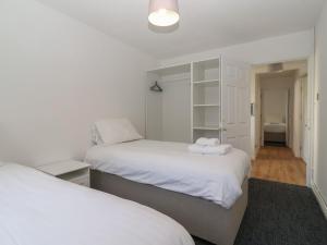 two beds in a room with white walls at A Devon Den at Harcombe House in Newton Abbot +77 photos