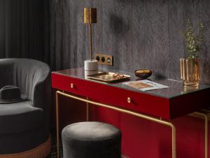 a red desk with a stool and a chair at Snob Hotel in Paris