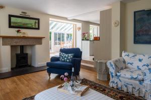 sala de estar con sillas azules y chimenea en Sea Lavender, en Thurlestone