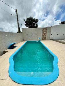a blue swimming pool on the side of a house at Chalés do Abraão in Martins
