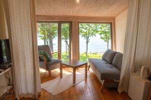 a living room with a couch and a table and a window at Guest House Vidlauči in Skulte