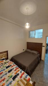 a bedroom with a bed and a ceiling at Nour Alkindi Nador in Nador