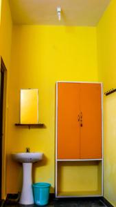馬哈巴利普拉姆的住宿－Srinivasa Residency，一间带水槽和黄色墙壁的浴室