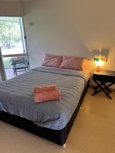 a bedroom with a bed with two towels on it at Bulgon Lodge in Collinsville +2 photos