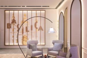a waiting room with chairs and a wall with a picture at Radisson Collection Hotel, Basilica Budapest in Budapest