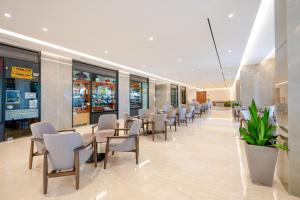 a waiting room with chairs and tables in a building at Calypso Beach in Faliraki +47 photos