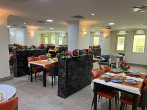 a restaurant with tables and chairs and flowers at Royal Heaven Hotel Qatar in Doha +16 photos
