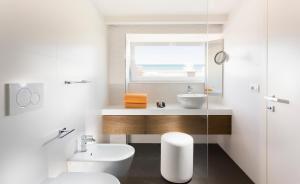 a white bathroom with a sink and a toilet at Hotel Corallo in Riccione