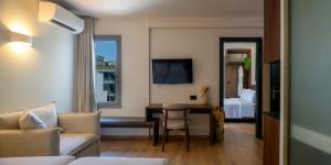 アテネにあるErmou 26 Hotelのベッドとデスクが備わるホテルルームと
