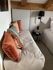 a bed with pillows on it in a bedroom at La Ferme du Golf in Megève
