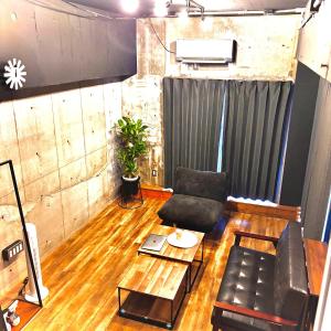 un salon avec un canapé et une table dans l'établissement Kumamoto Serviced Apartment Sakura Mee 桜美, à Kumamoto