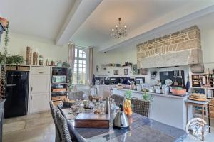a kitchen with a dining table and a brick wall at La gentilhommiere in La Bazouges-du-Désert