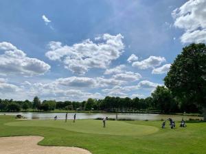 a group of people playing golf on a golf course at La gentilhommiere in La Bazouges-du-Désert