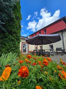 an umbrella and flowers in front of a building at Pensjonat Li-Mar in Pisz