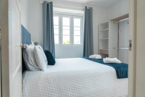 una camera da letto con un grande letto bianco con cuscini di Casa do Porto ad Angra do Heroísmo