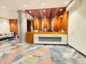 a lobby with a large fireplace in a room at Hotel Neem Heritage in Shirdi