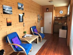 a living room with two blue chairs and a table at Chalupa U Vinaře - tiny house in Radějov