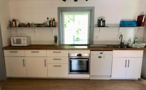 a kitchen with white cabinets and a sink and a window at Ferienhaus in Borghamn, Vättern in Borghamn +26 photos