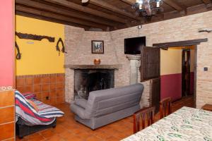 un salon avec un canapé et une cheminée dans l'établissement Alojamiento rural el olivar, à Casasbuenas