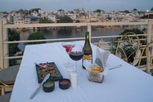 a white table with a bottle of wine and wine glasses at DERA PICHOLA- A Lake Facing Boutique Hotel in Udaipur