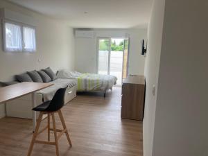 a bedroom with a bed and a desk with a chair at Studio avec courette au calme in Saran