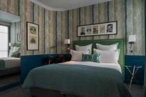 - une chambre avec un grand lit et une tête de lit verte dans l'établissement Hôtel Adèle & Jules, à Paris