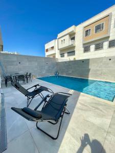 a swimming pool with a chair next to a building at Luxury house in Martil in Martil