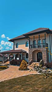 a large house with a balcony on top of it at Agropensiunea Izana in Drăguţeşti