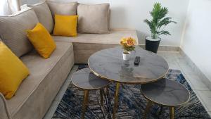 una sala de estar con un sofá y una mesa en Winde Cozy Apartment Ruiru-Membley, en Ruiru