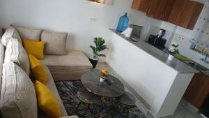 pequeña sala de estar con mesa y cocina en Winde Cozy Apartment Ruiru-Membley, en Ruiru