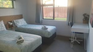a room with two beds and a desk and a window at Spacious on Sarita in Cromwell +4 photos