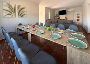 a dining room with a long table and blue chairs at TAYP OrigenHomes in Collado